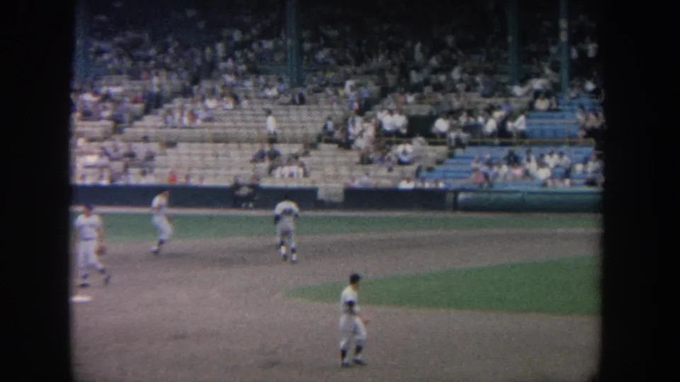 1964 New York home-movie frame of baseball players moving across the infield during warmups before a game.