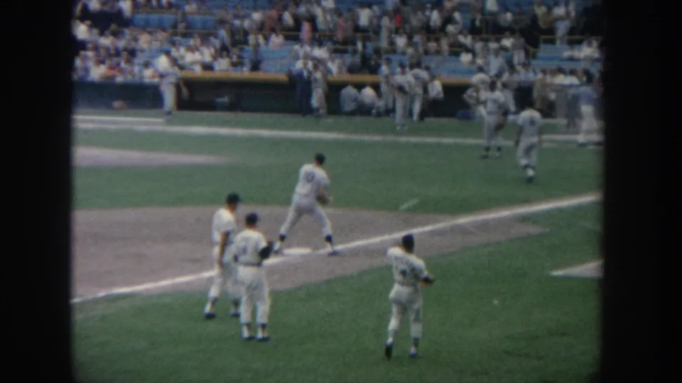 1964 New York home-movie frame of baseball players in white uniforms warming up on the field before play.