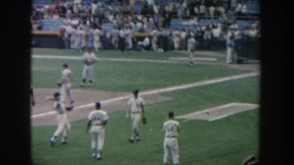 1964 New York baseball warm-up scene with uniformed players on the field and a crowded stadium visible beyond the infield.