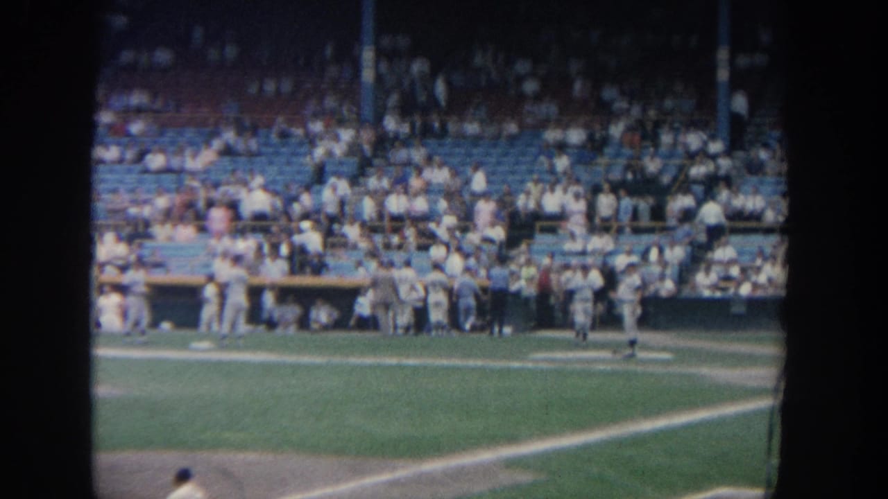 Players and spectators are seen from the stands across the baseball field.