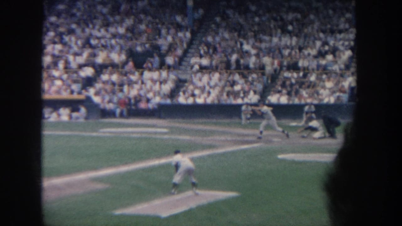 Pitcher on the mound with batter and catcher near home plate in a crowded stadium.