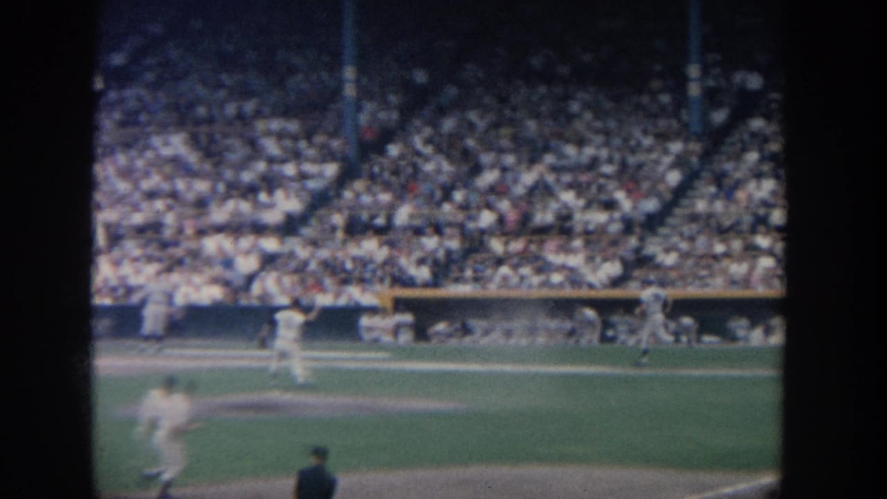 1964 New York 8mm view of baseball players on the field before a densely filled stadium crowd.