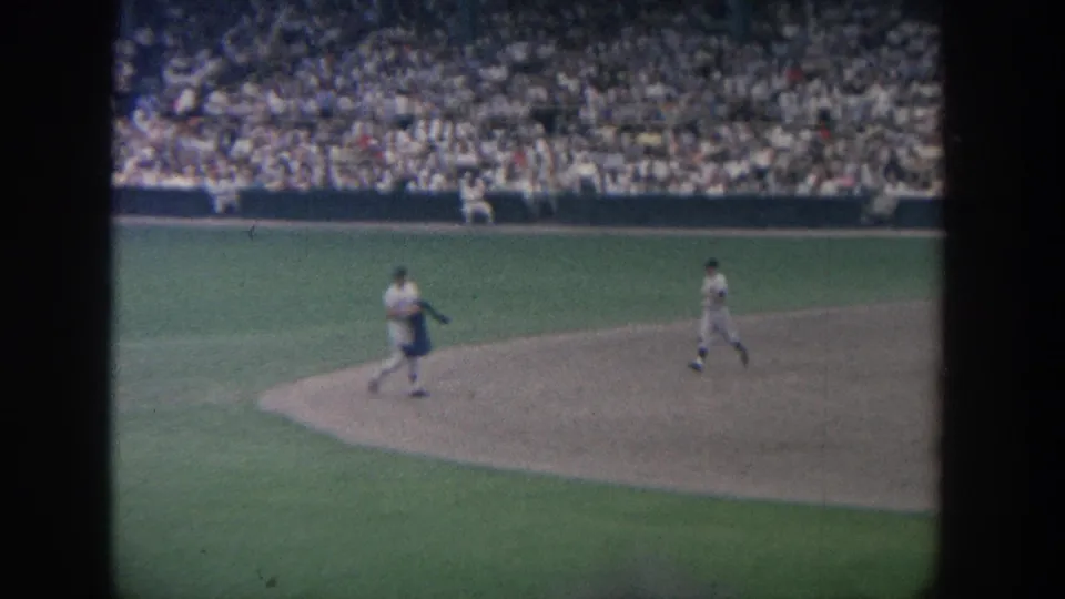 1964 New York 8mm view of baseball players around the infield, filmed from the stands during a crowded game.