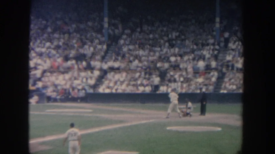 1964 New York baseball game view of a batter at home plate, catcher, umpire, fielder, and packed grandstand.