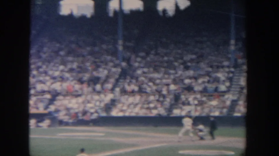 1964 New York baseball scene with a batter at home plate, catcher and umpire behind, and a large crowd across the grandstand.
