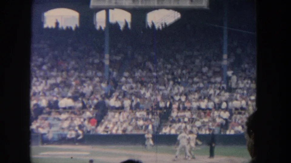 1964 New York baseball scene with the batter moving out of the box, catcher and umpire near home plate, and spectators filling the stands.
