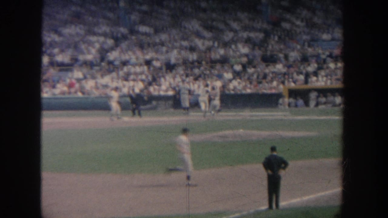 Baseball players and an official near the infield with crowded stands behind them.