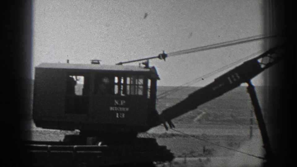 1936 California frame showing the machinery cab, visible lettering, crane arm, rails, cables, and open hills beyond.