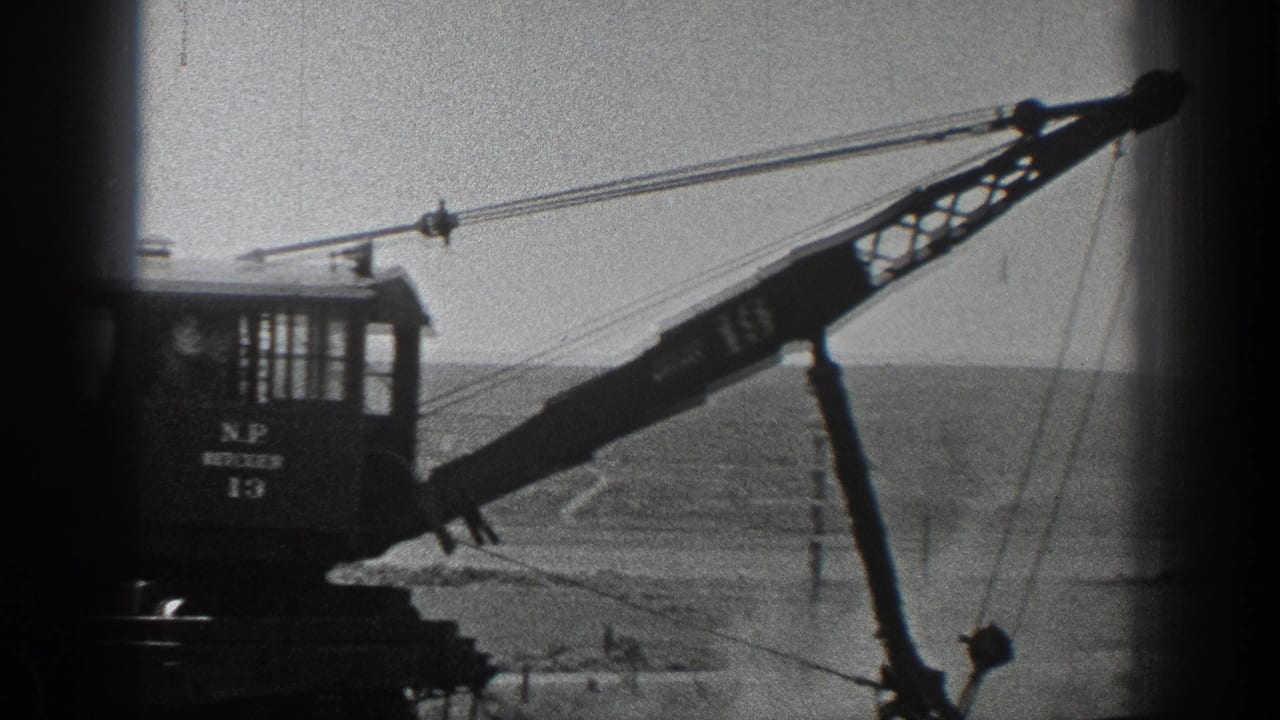 1936 California 8mm frame showing a marked rail crane with its boom extended over open terrain.
