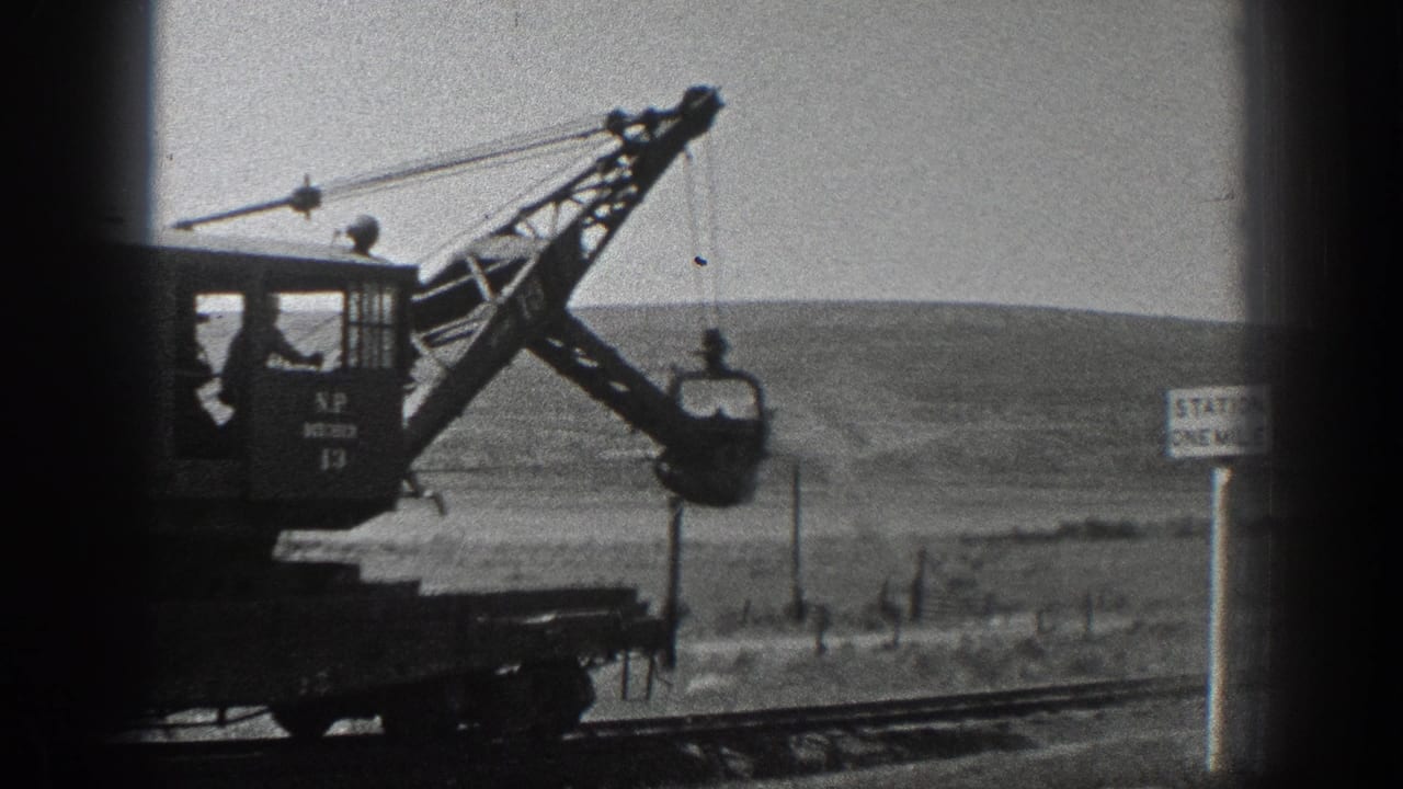 1936 California frame of a crane labeled N.P. 13 lifting a bucket beside rail tracks in open country.