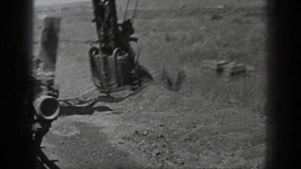 The lower boom, cable and digging attachment of the 1936 ditcher crane appear over a rough open field.