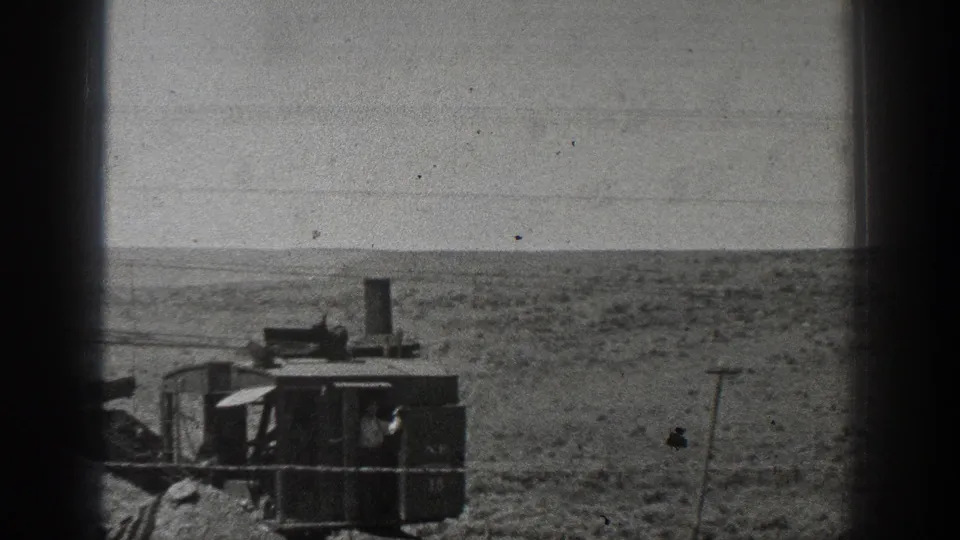 The steam-powered machine appears farther across the California desert, with the worker partly visible inside the dark cab.