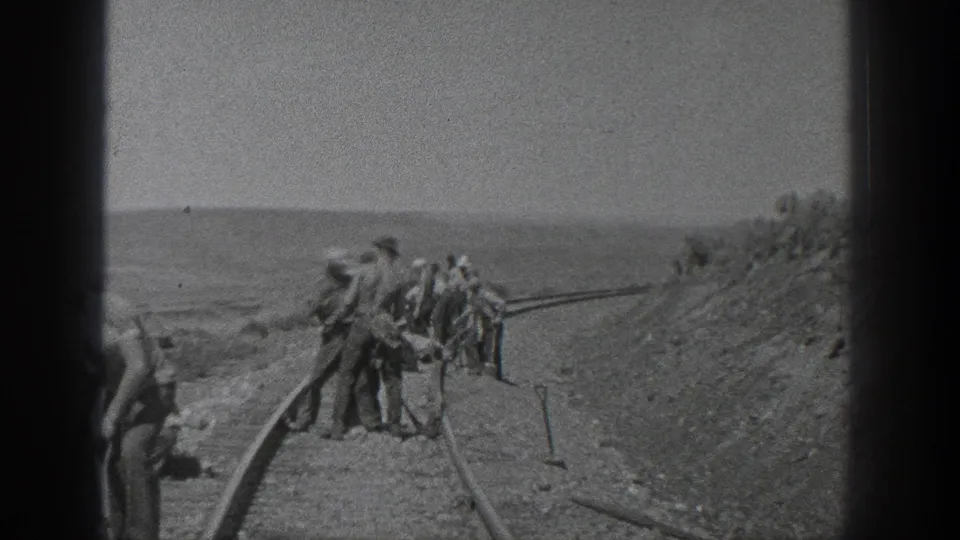 California 1936 home-movie frame showing men around the railway line, with one figure partly cut off at the frame edge.