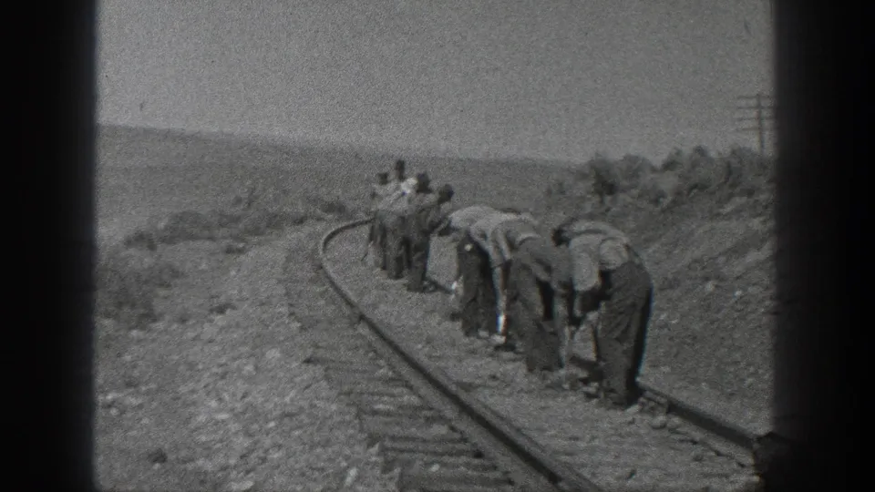 In 1936 California home-movie footage, a group of workers appears to clear or inspect a curved railroad track by hand.