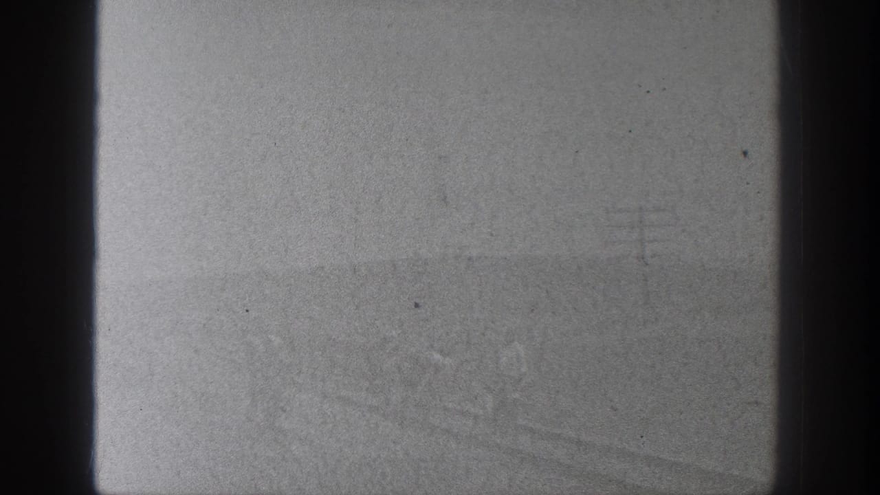 1936 California 8mm frame appears largely overexposed or leader-like, with dark gate edges and small dust marks visible.
