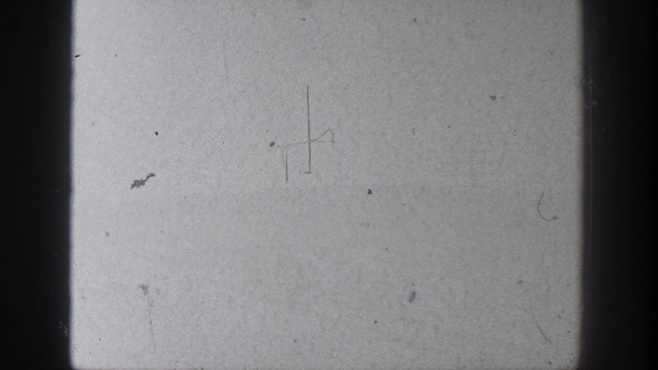 A pale 8mm frame from the 1936 California clip shows film borders, dust, and faint marks rather than clear landscape detail.