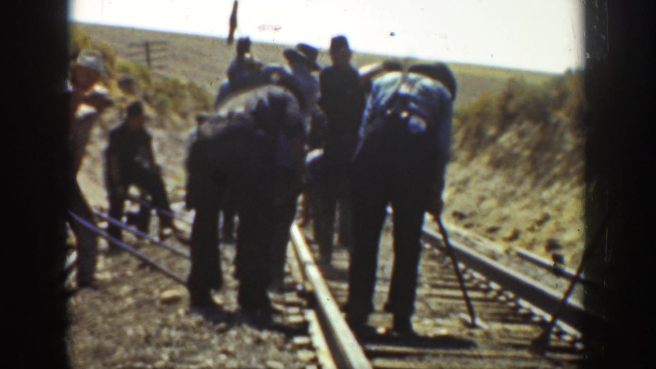 1936 California 8mm frame showing railway workers on a rural track, with tools, rails, wooden ties, and dry embankments visible.