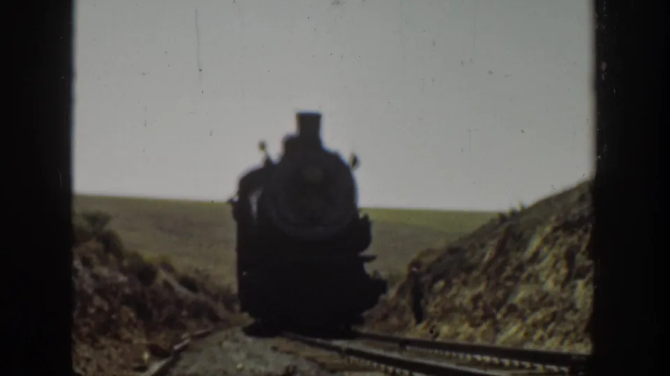 1936 California 8mm frame with the approaching steam locomotive close to camera on rural tracks.