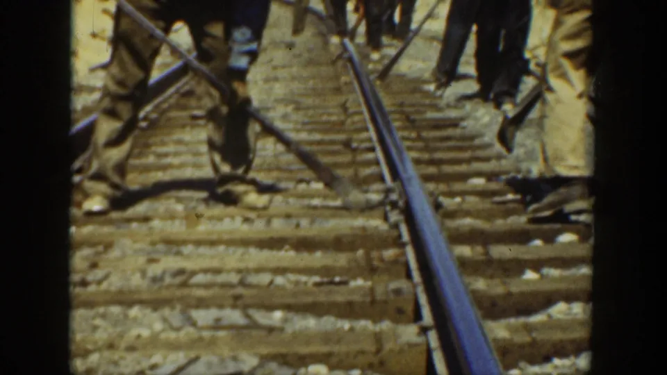 Workers stand on the track with tools during apparent railway maintenance in 1936 California home-movie footage.