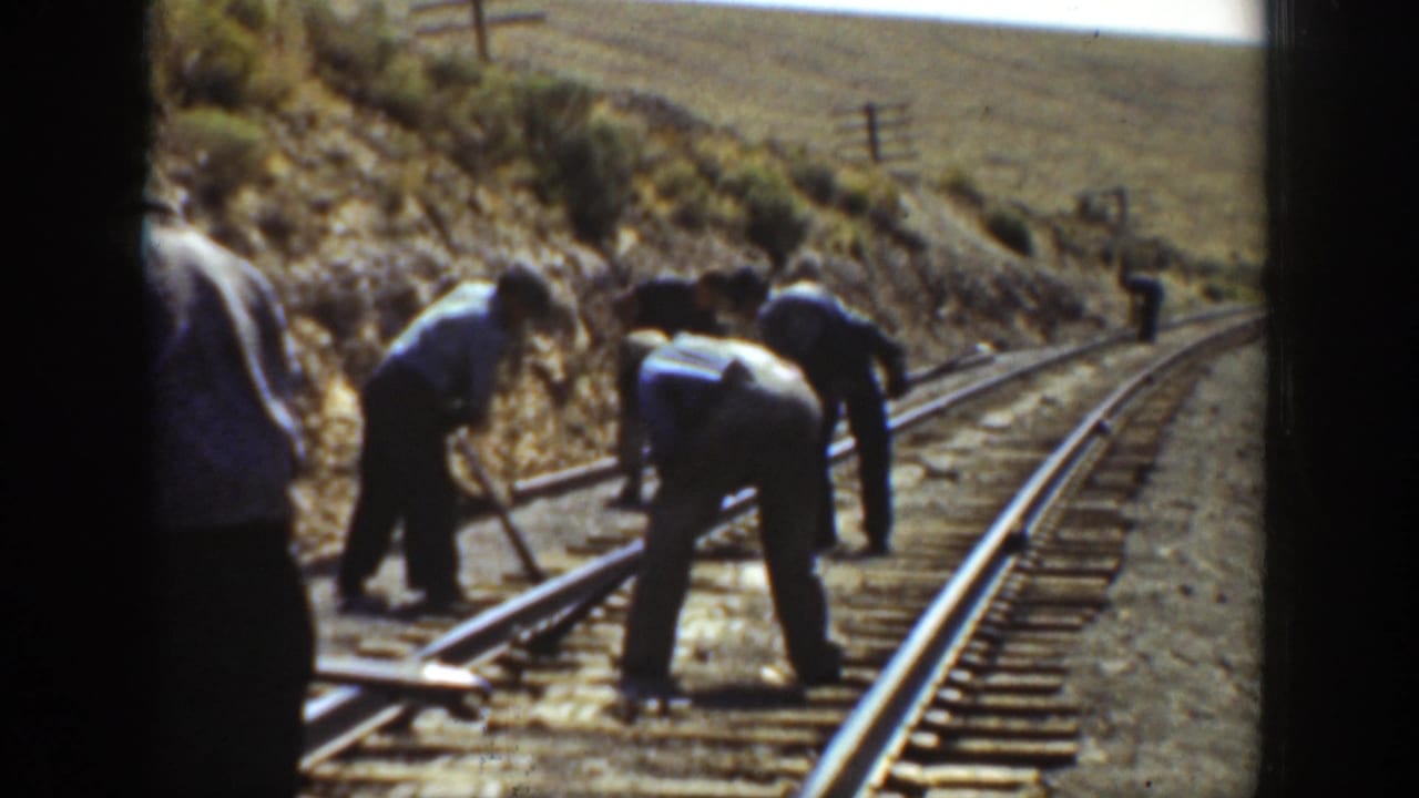 Men appear to adjust or maintain railroad rails on a curved track in the supplied 1936 California footage.