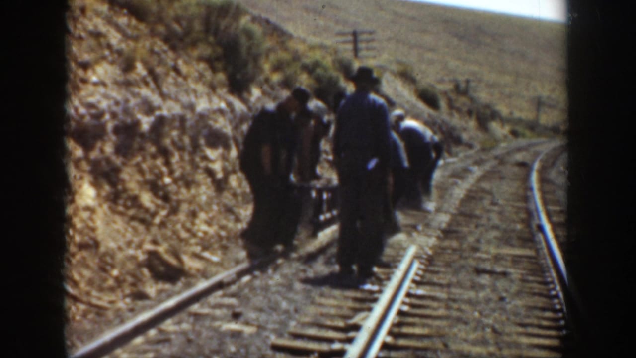 Railway workers repair track along a winding rail line in California, 1936, seen through an 8mm home-movie frame.