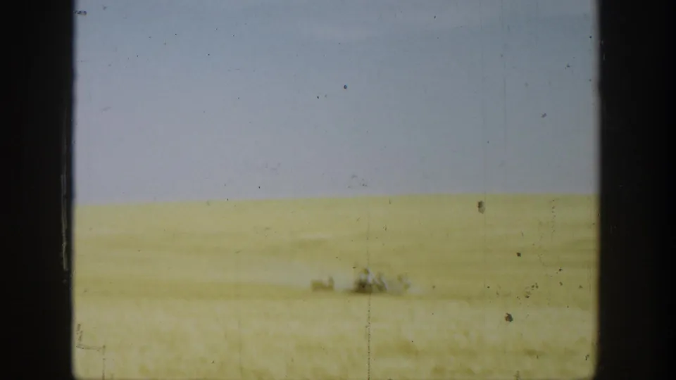Final 1936 California field view showing a distant reaper against a wide band of wheat and sky.