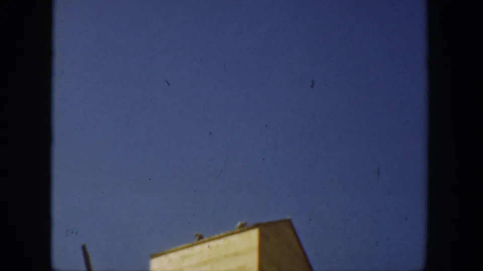 1936 California 8mm frame tilted upward to clear blue sky, with only the top edge of a yellow farm structure visible.