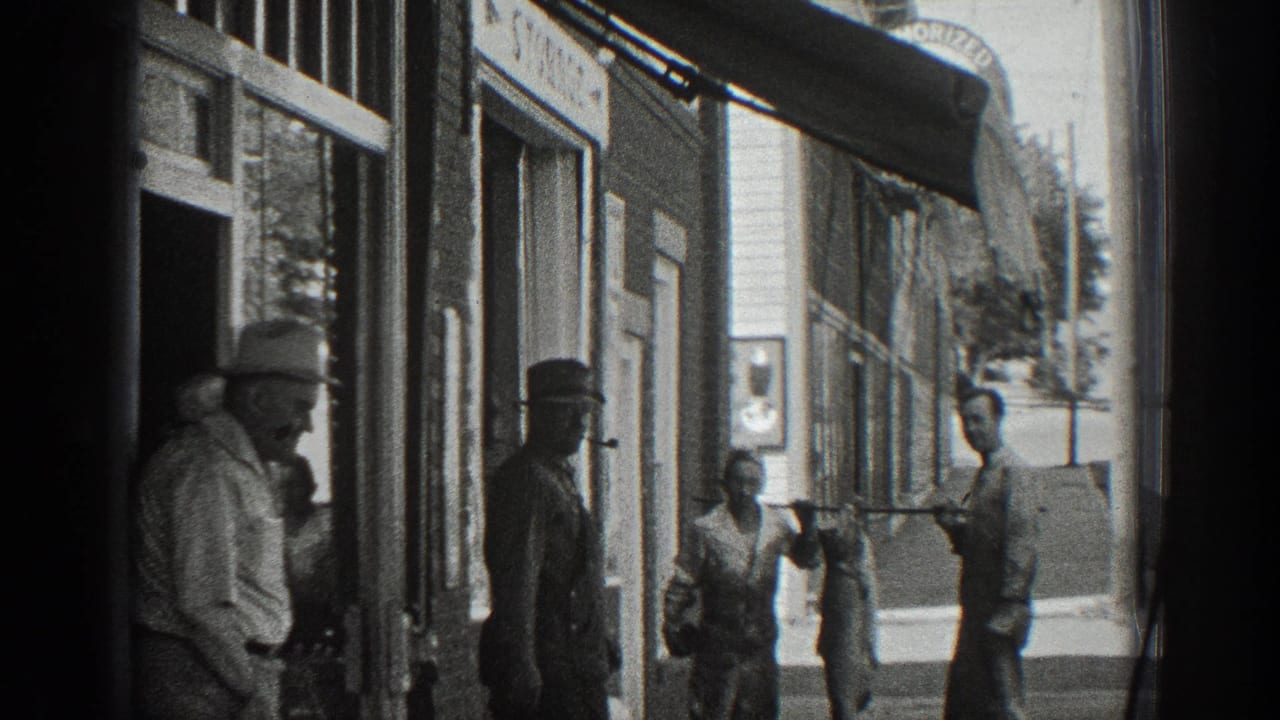 Several men stand outside storefronts as a large fish hangs from a pole on the sidewalk.