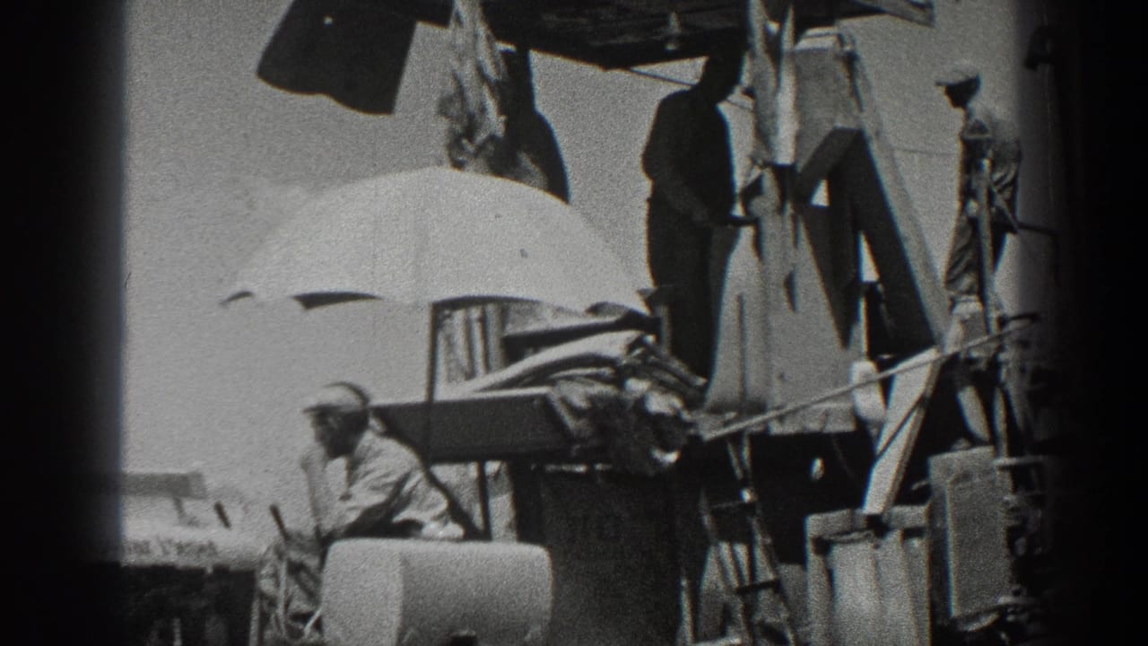 1936 California 8mm frame showing rural workers around a combine harvester, with grain sacks and a shade umbrella on the machinery.