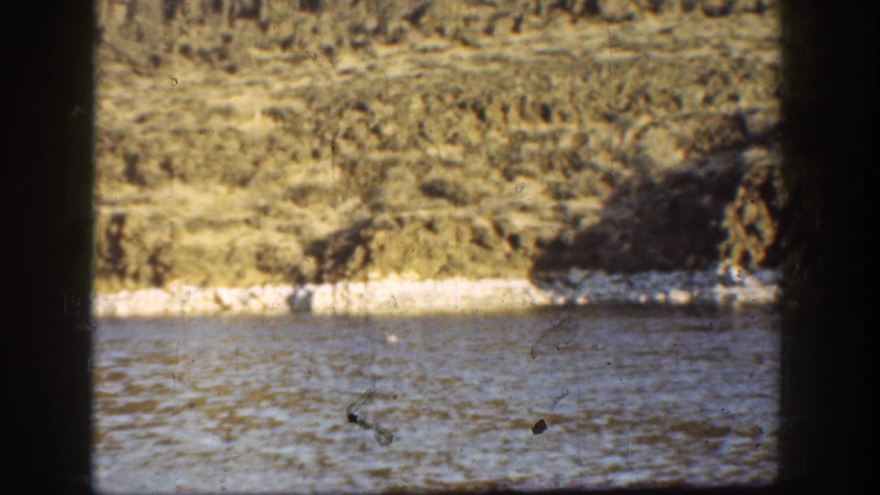 1936 California 8mm view of a riverbank and layered arid hillside, partially obscured by dark vertical frame edges.