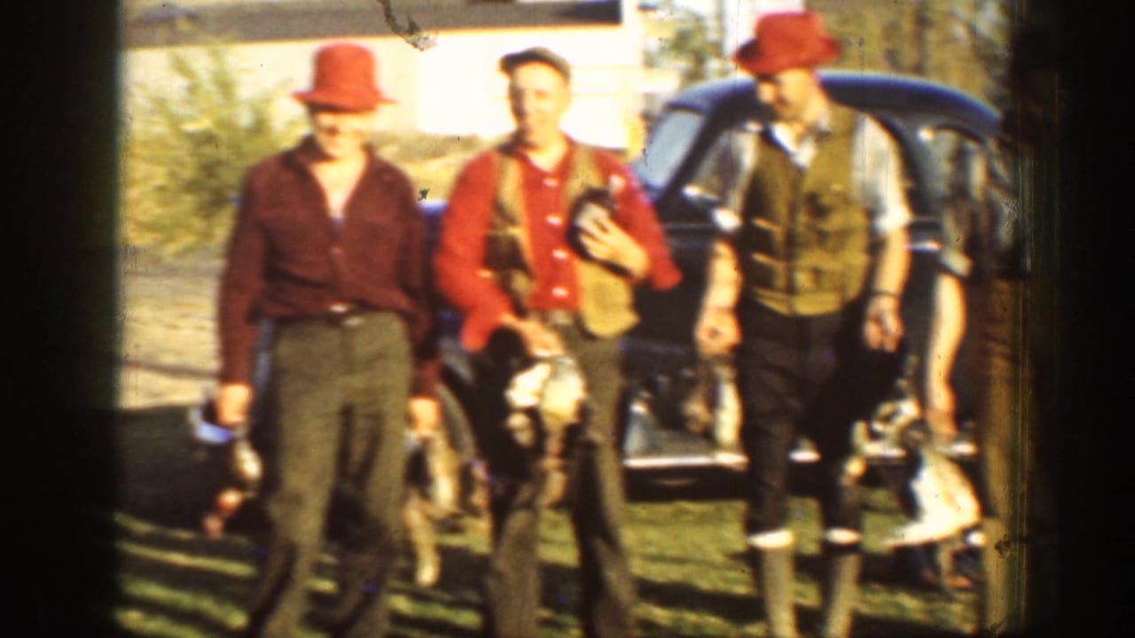 In 1936 California home-movie footage, three adult hunters pose near a dark car with game birds and period outdoor clothing.