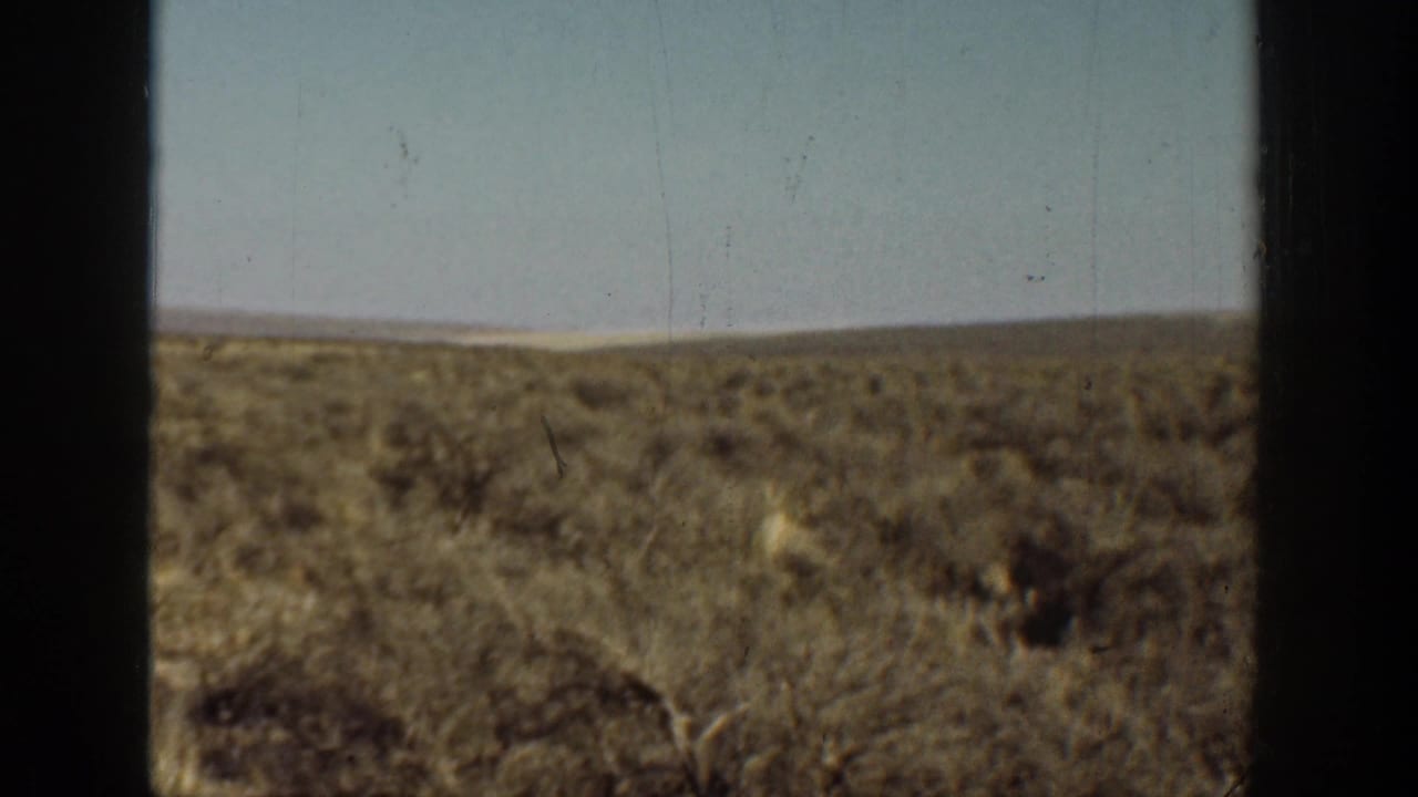 1936 California 8mm view of dry open brushland and pale sky divided by a dark window frame.