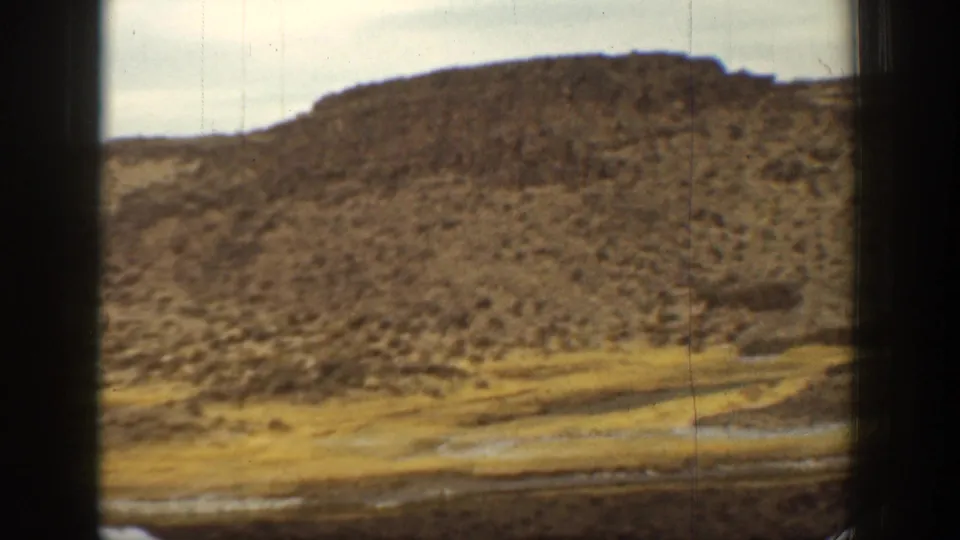 1936 California 8mm view of a rounded rocky hillside and sparse vegetation above basin terrain.