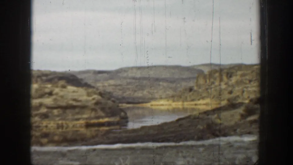 A wide 8mm view shows water winding through rocky, dry hills in the California landscape described for the clip.