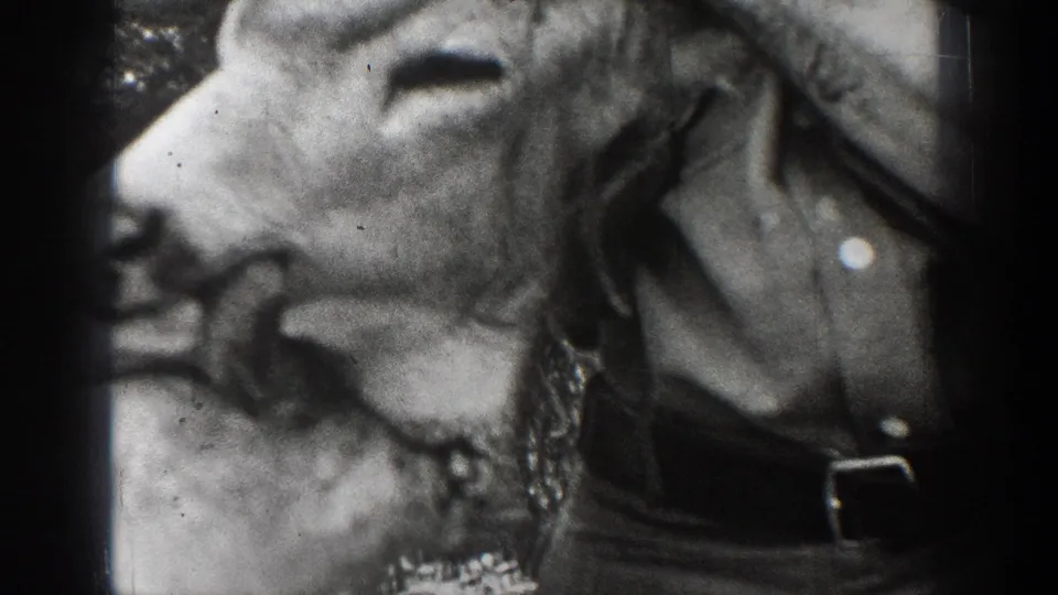 Close 1939 Chelan home-movie view of a mounted deer head beside the torso of a man in outdoor clothing.