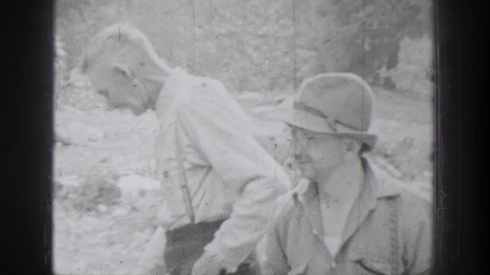 Chelan 1939 home-movie frame with two men close together outdoors, one wearing a brimmed hat.