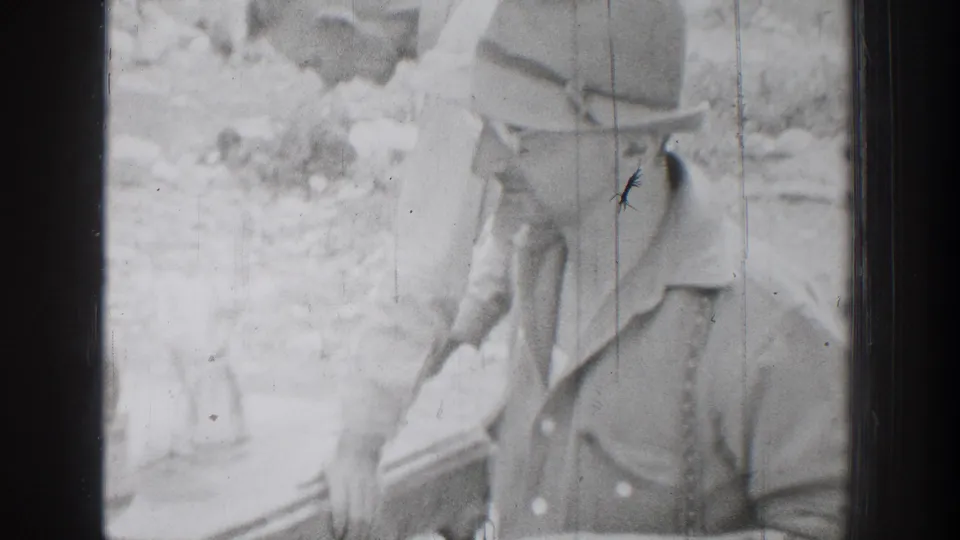 Close 1939 Chelan home-movie view of a man in a brimmed hat and open-collar shirt, with wooded background.