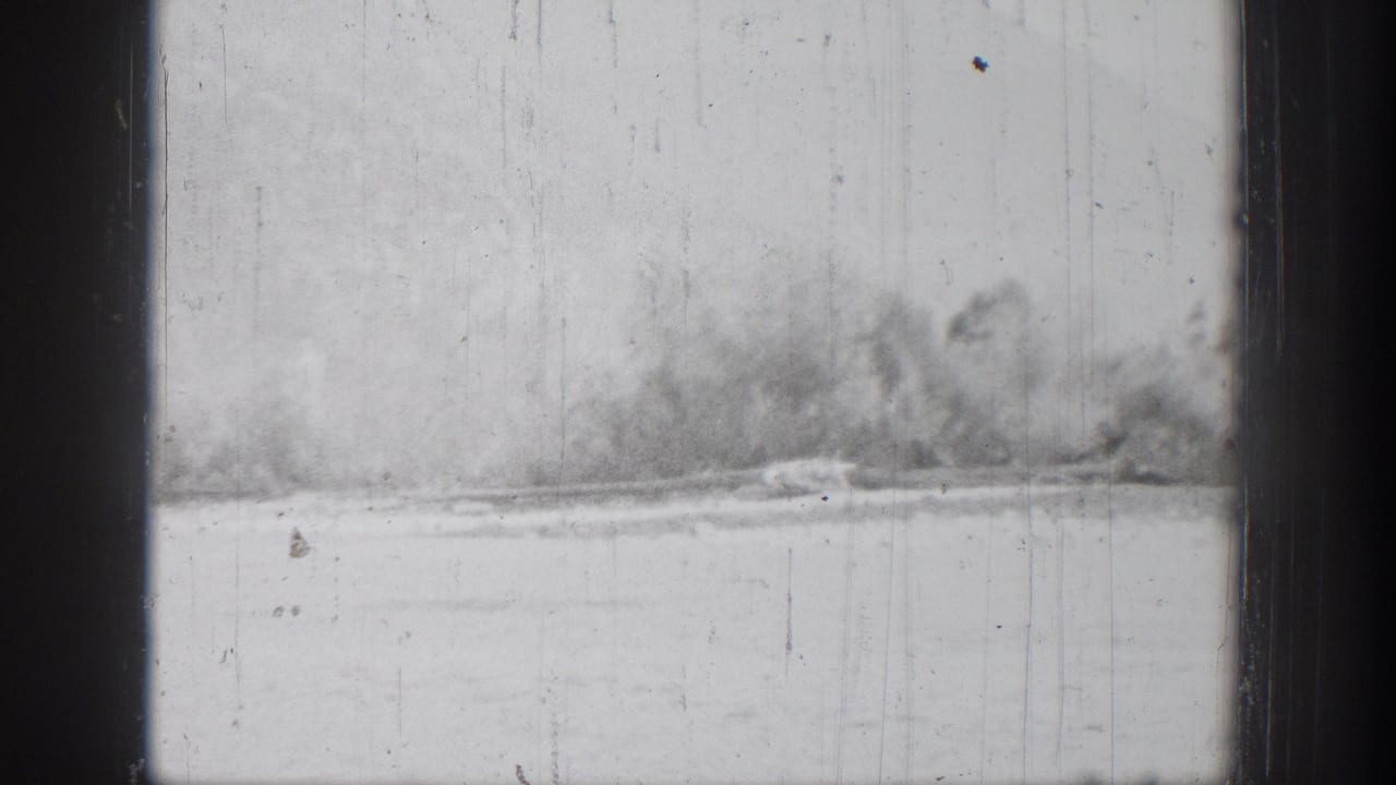 Soft, overexposed 8mm frame of a blurred Chelan shoreline and calm water after the boat view shifts away.