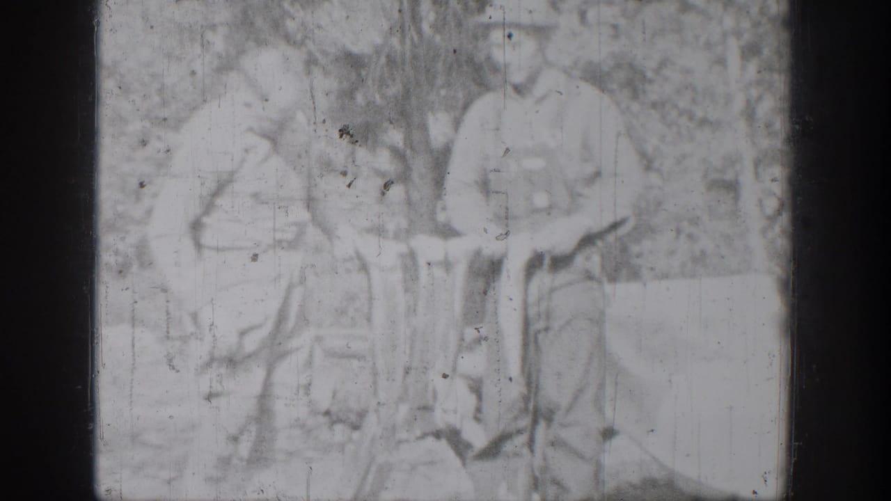 Faint overexposed frame of two people standing with a fish catch outdoors.