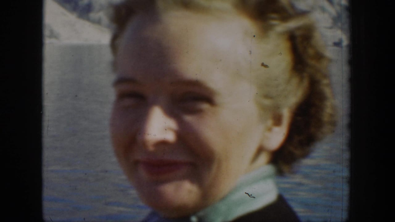 A smiling woman appears beside lake water in 1939 Chelan, Washington home-movie footage.