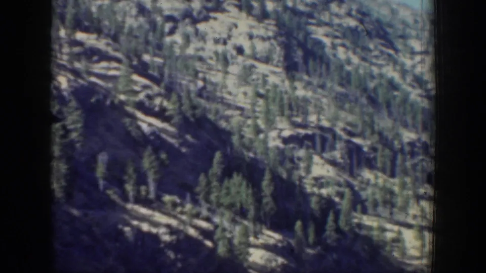 A forested mountain slope near Chelan appears in faded 8mm lake-travel footage.