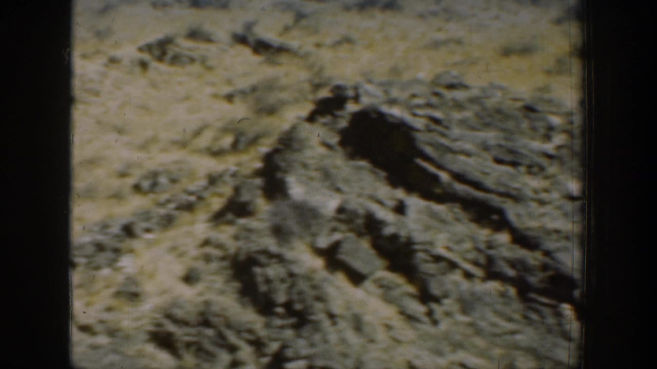 Close view of sunlit rock outcrops and dry grass on a mountain slope.