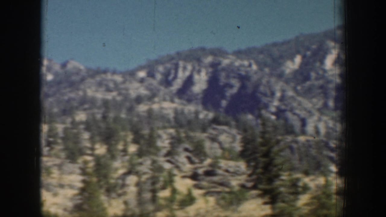 Chelan, Washington area mountain ridge in 1939 home-movie footage, viewed through a dark lift or vehicle frame.