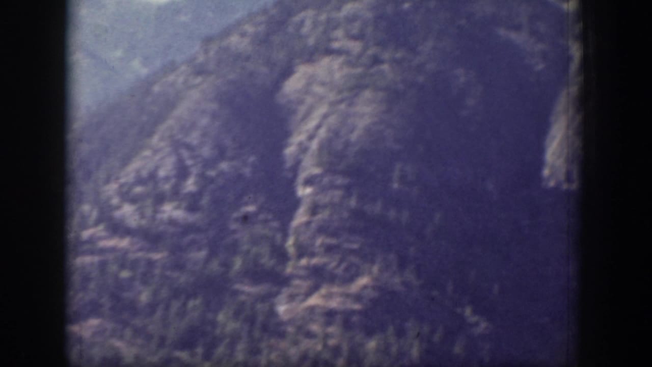 1939 Chelan, Washington home-movie frame showing a close view of rugged mountain slopes beneath pale blue sky.