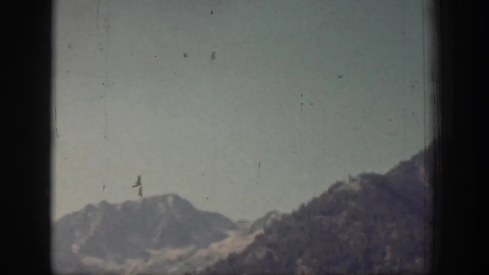 A hazier 1939 Chelan mountain view shows a low ridge and open sky, with dust marks and soft 8mm color visible.