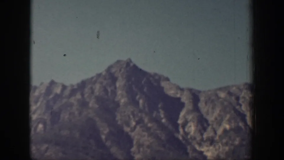 1939 Chelan, Washington 8mm frame showing rugged mountain peaks beneath a pale sky with visible film wear.