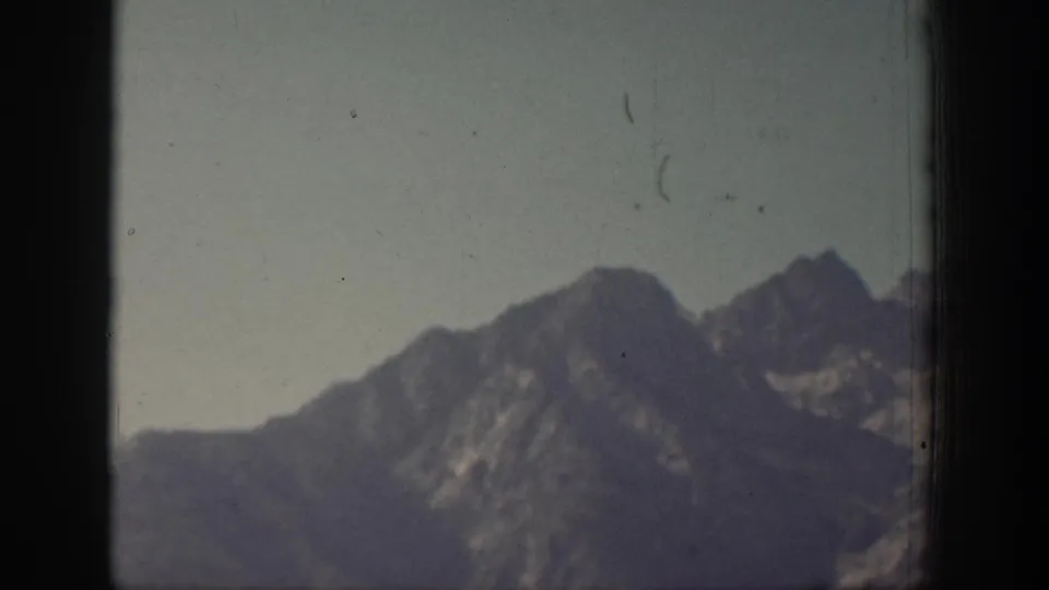 Faded 1939 Chelan 8mm frame with a soft mountain silhouette, ridgelines, and visible film specks.