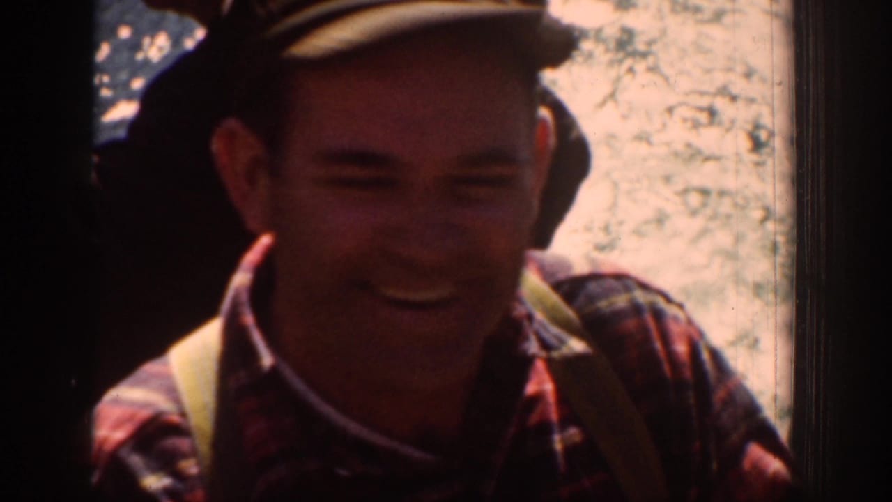 Chelan 1939 home-movie frame with a smiling adult in a cap and plaid shirt, partly shadowed in bright outdoor light.