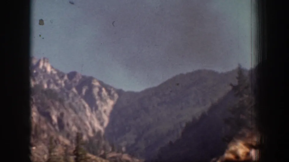 Chelan-area mountain ridges appear in a soft, handheld 1939 8mm landscape view.