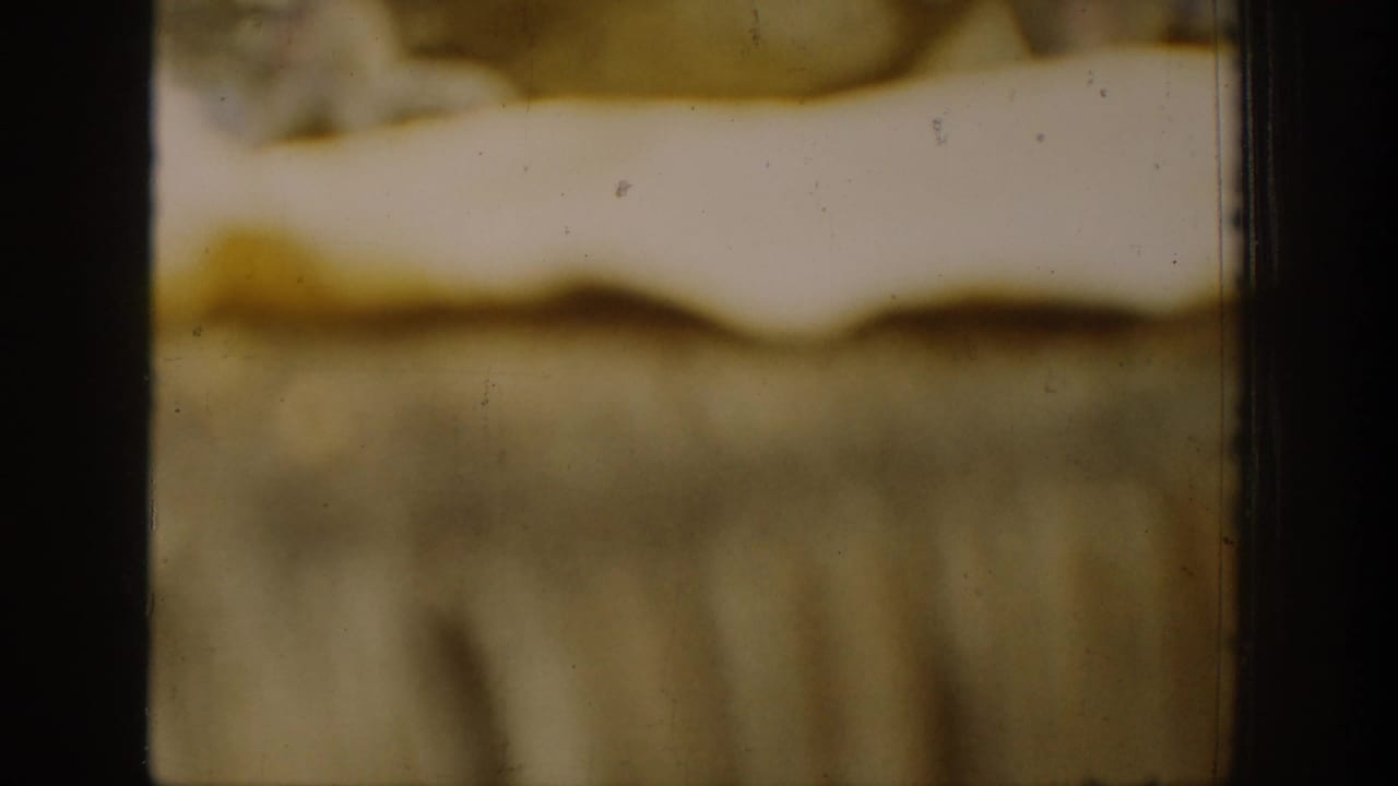 Soft, blurred 1939 Chelan home-movie frame showing indistinct landscape tones, dark film borders, and visible archival film texture.